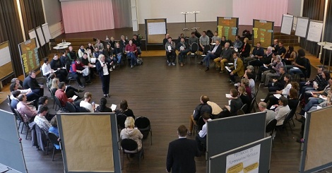 Susanne Weber im Stuhlkreis einer großen Gruppe von 80 Teilnehmern