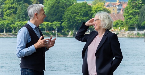 zwei Personen im Gespräch, im Hintergrund der Bodensee